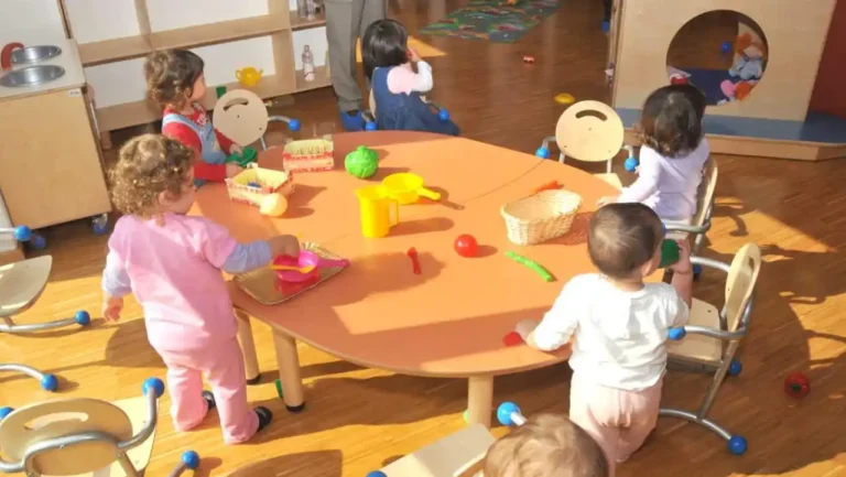 Bambini che giocano in un asilo nido con insegnanti in un ambiente educativo accogliente