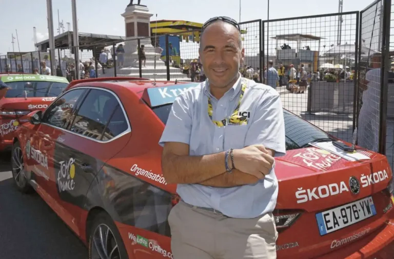 Gianluca Crocetti, presidente della giuria al Tour de France 2025, accanto ad una delle macchine rosse ufficiali